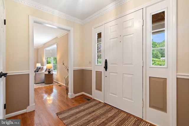  - entryway with wood finished floors and ornamental molding