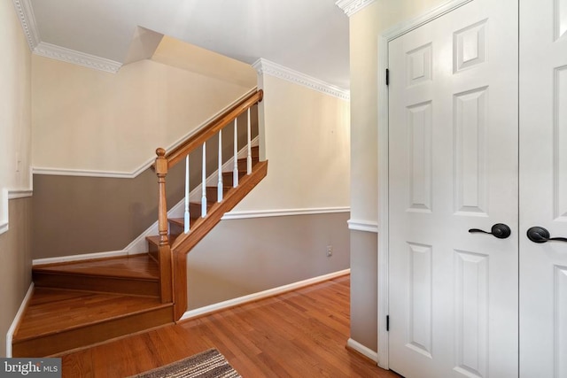  - stairway featuring wood finished floors and crown molding