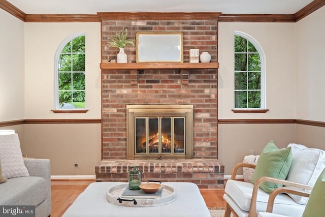 - living room with wood finished floors, healthy amount of natural light, ornamental molding, and a brick fireplace