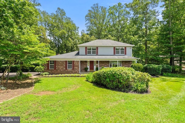  - traditional-style house with a front lawn and brick siding