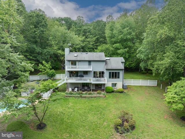  - rear view of property featuring a deck, a chimney, a forest view, stairs, and a patio area