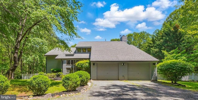  - mid-century inspired home featuring a chimney, driveway, an attached garage, and roof with shingles