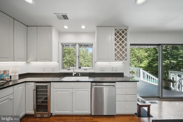  - kitchen featuring stainless steel dishwasher, beverage cooler, a sink, white cabinets, and recessed lighting