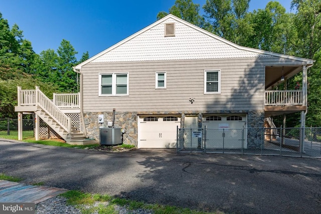8314 Old Mill Ln, Spotsylvania, VA 22551 - view of property exterior featuring stairway, stone siding, driveway, an attached garage, and a gate