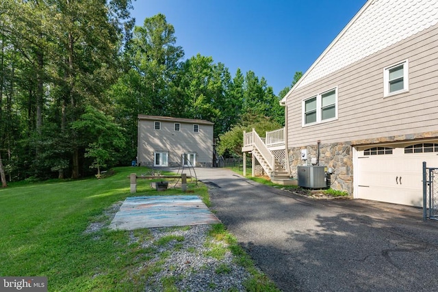 8314 Old Mill Ln, Spotsylvania, VA 22551 - view of side of home with stone siding, a lawn, driveway, stairway, and an attached garage