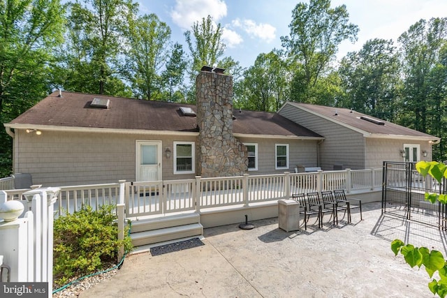 8314 Old Mill Ln, Spotsylvania, VA 22551 - back of property with a patio, a chimney, a wooden deck, and a shingled roof