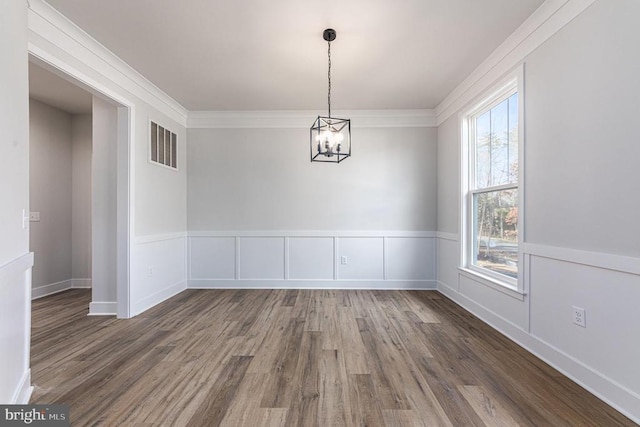 unfurnished dining area with wood finished floors and a chandelier