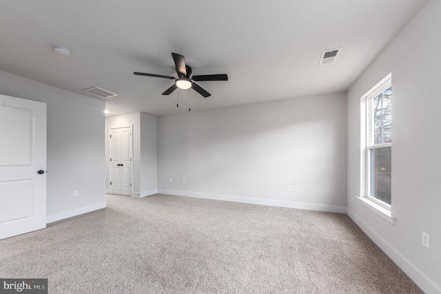 unfurnished room featuring a ceiling fan, carpet flooring, a smoke detector, and baseboards