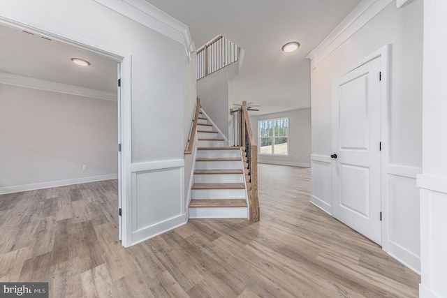 stairs featuring wood finished floors, ornamental molding, baseboards, and recessed lighting