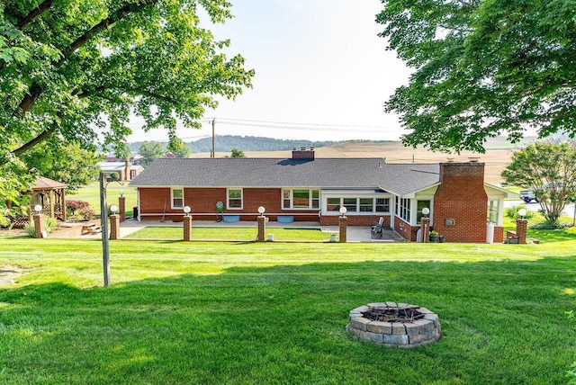 5213 Rawley Pike, Rockingham, VA 22801 - rear view of house with an outdoor fire pit, a chimney, brick siding, and a yard