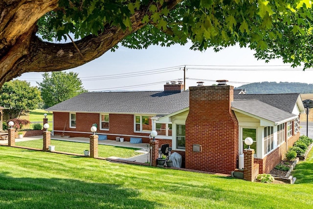 5213 Rawley Pike, Rockingham, VA 22801 - back of house featuring a chimney, a lawn, brick siding, and roof with shingles