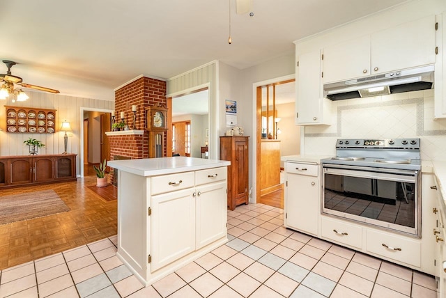 5213 Rawley Pike, Rockingham, VA 22801 - kitchen with under cabinet range hood, stainless steel range, ceiling fan, light countertops, and wood walls