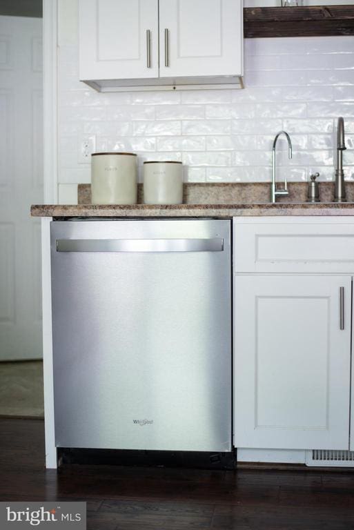 bar area featuring dishwasher, decorative backsplash, dark wood finished floors, and a sink