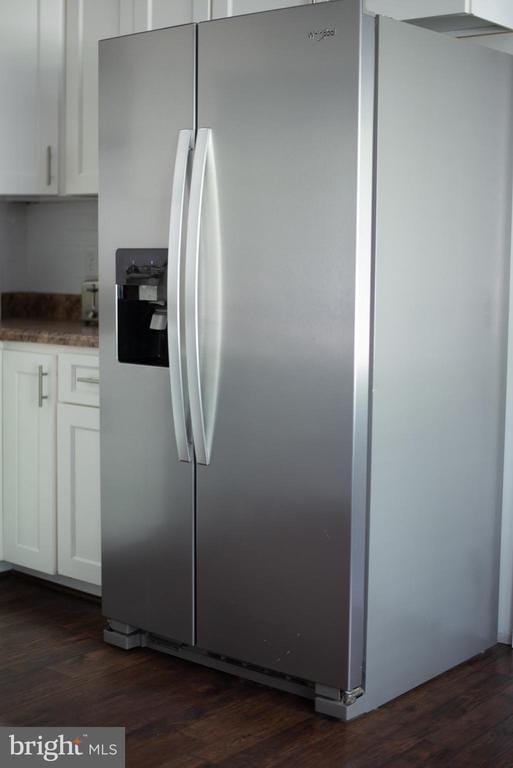kitchen featuring stainless steel fridge, white cabinets, and dark wood-style floors