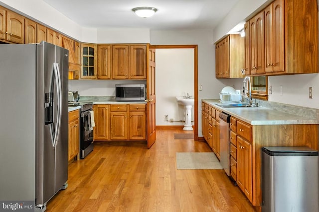 60 Mountain Breeze Ln, Syria, VA 22743 - kitchen featuring stainless steel appliances, light countertops, brown cabinets, light wood finished floors, and glass insert cabinets