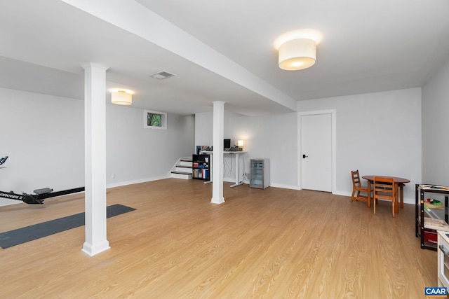 finished below grade area featuring baseboards, stairs, light wood finished floors, and visible vents