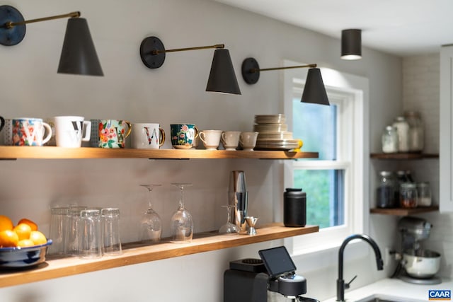 interior space featuring backsplash, open shelves, butcher block countertops, and a sink