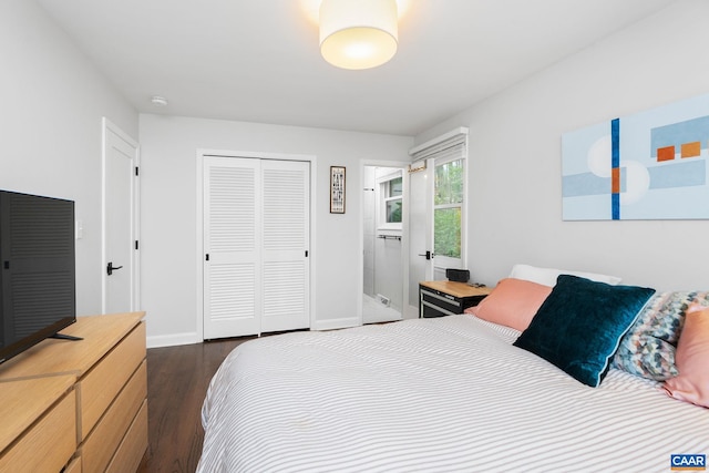 bedroom with a closet, dark wood-type flooring, and baseboards