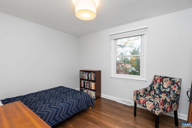 bedroom with visible vents, wood finished floors, and baseboards