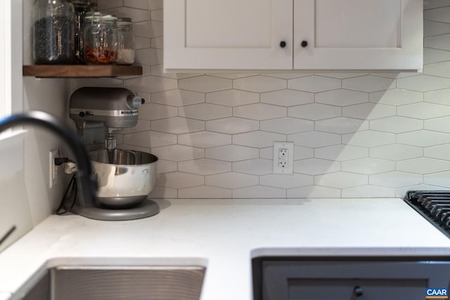 interior space with light countertops, white cabinetry, and backsplash