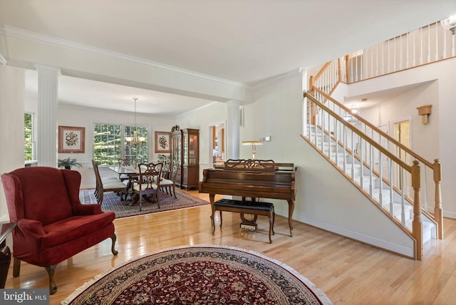 17277 Kettlebrook Lndg, Jeffersonton, VA 22724 - living area with decorative columns, wood finished floors, stairway, crown molding, and a chandelier
