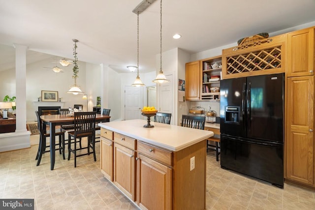 17277 Kettlebrook Lndg, Jeffersonton, VA 22724 - kitchen featuring black fridge, open shelves, a ceiling fan, a kitchen island, and a warm lit fireplace