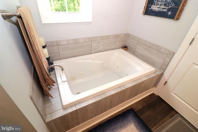 bathroom featuring a jetted tub and wood finished floors