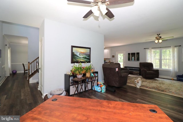 living room featuring a ceiling fan, wood finished floors, stairway, and baseboards