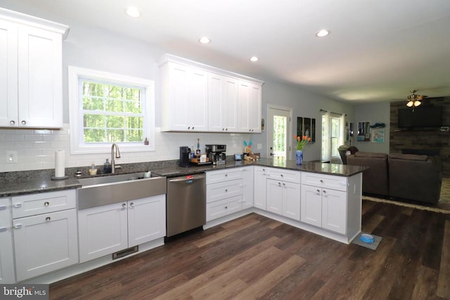 kitchen with stainless steel dishwasher, a peninsula, open floor plan, white cabinets, and recessed lighting