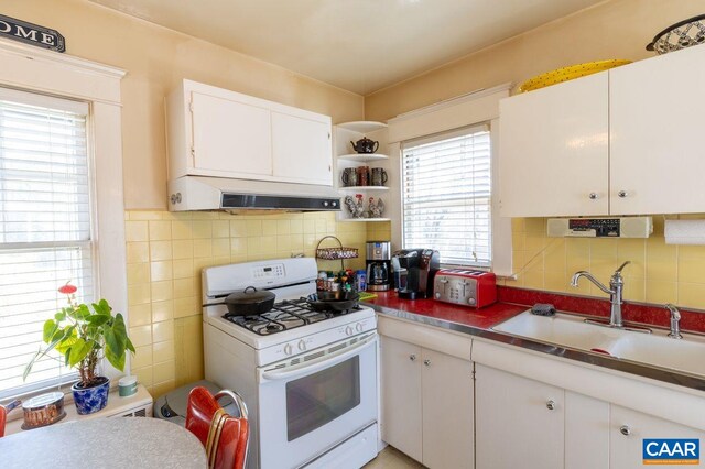 1700 Monticello Rd, Charlottesville, VA 22902 - kitchen featuring a sink, open shelves, decorative backsplash, white gas stove, and white cabinets