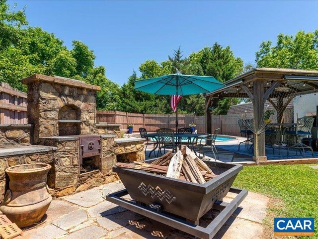 1700 Monticello Rd, Charlottesville, VA 22902 - view of patio featuring an outdoor stone fireplace, a gazebo, a fenced in pool, and a fenced backyard
