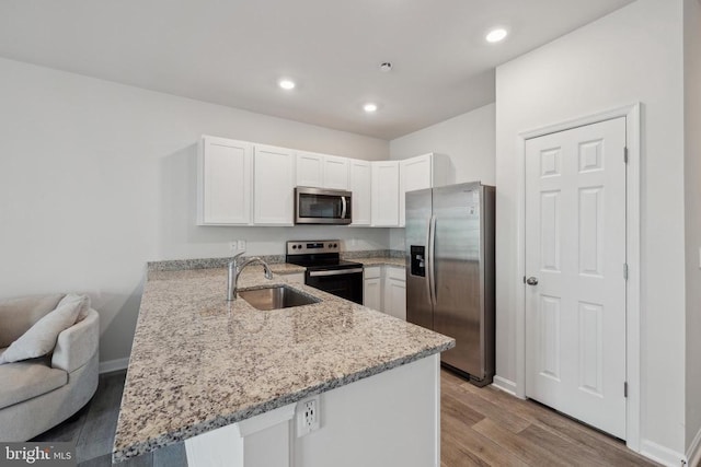 226 Baker Dr, Luray, VA 22835 - kitchen featuring appliances with stainless steel finishes, a sink, a peninsula, white cabinets, and light stone countertops