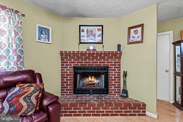54 Courthouse Mountain Rd, Madison, VA 22727 - living room featuring a textured ceiling, a brick fireplace, baseboards, and wood finished floors
