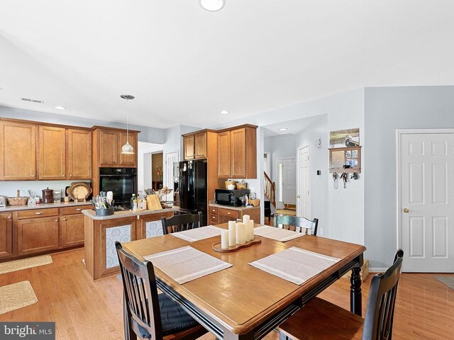  - dining space featuring light wood-style floors, recessed lighting, and stairway