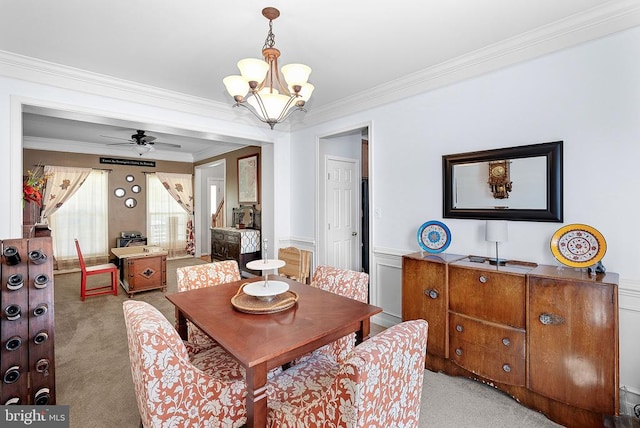  - carpeted dining space featuring crown molding, a chandelier, a wainscoted wall, and a ceiling fan
