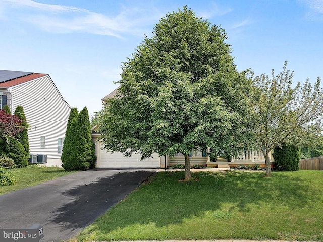  - obstructed view of property with a front lawn, driveway, and central AC