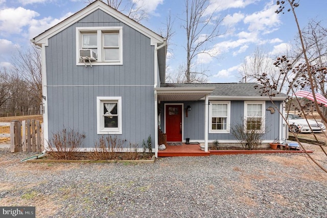 view of front of home featuring a shingled roof, cooling unit, and fence