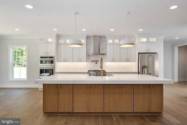 8630 Rosni Way, Fredericksburg, VA 22407 - kitchen with appliances with stainless steel finishes, wall chimney range hood, crown molding, light countertops, and a spacious island
