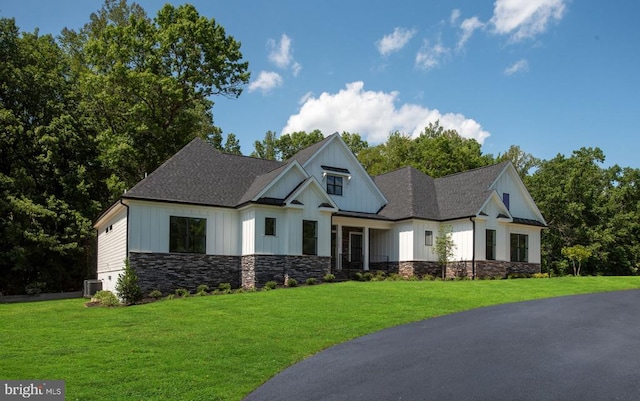 8630 Rosni Way, Fredericksburg, VA 22407 - view of front of home featuring board and batten siding, a front lawn, stone siding, and roof with shingles