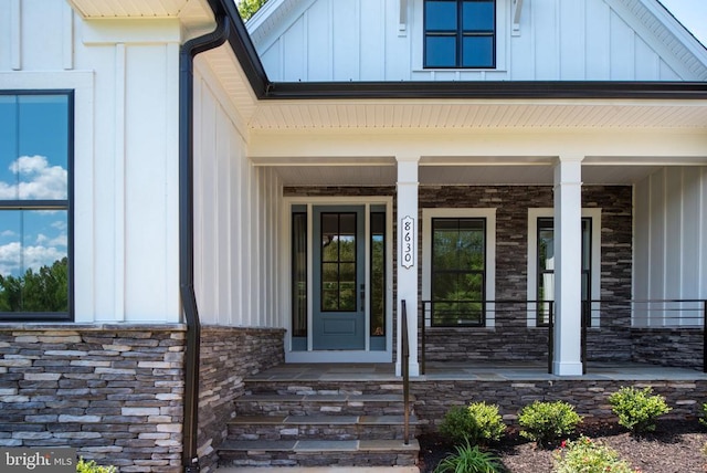 8630 Rosni Way, Fredericksburg, VA 22407 - view of exterior entry featuring board and batten siding, stone siding, and covered porch