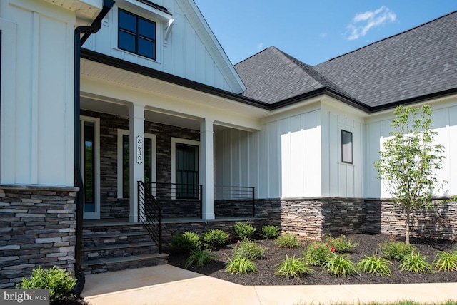 8630 Rosni Way, Fredericksburg, VA 22407 - view of exterior entry with board and batten siding, stone siding, covered porch, and roof with shingles