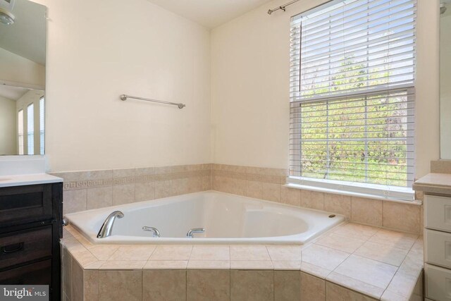 bathroom featuring vanity, healthy amount of natural light, and a garden tub