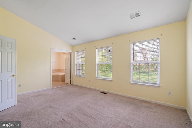 unfurnished bedroom featuring carpet floors, baseboards, lofted ceiling, and connected bathroom