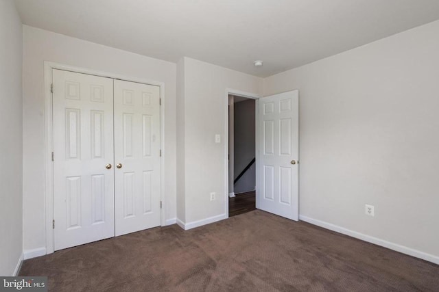 unfurnished bedroom featuring carpet, baseboards, and a closet