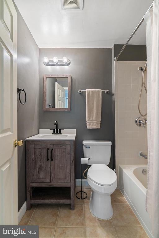 full bathroom featuring baseboards, toilet, vanity, and tile patterned flooring