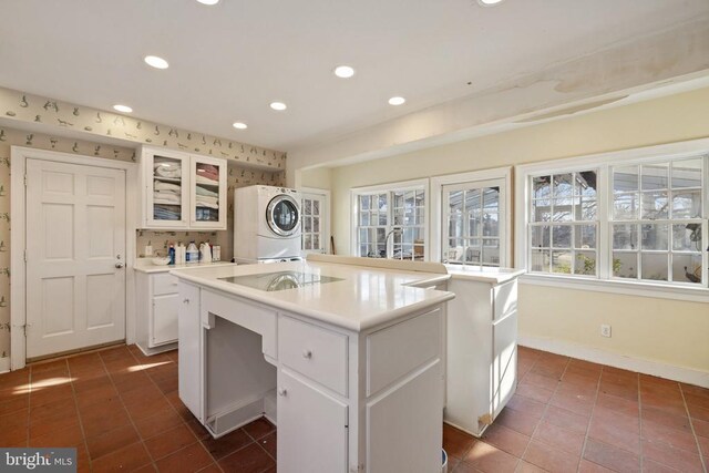  - laundry room featuring estacked washer and dryer, recessed lighting, and dark tile patterned floors