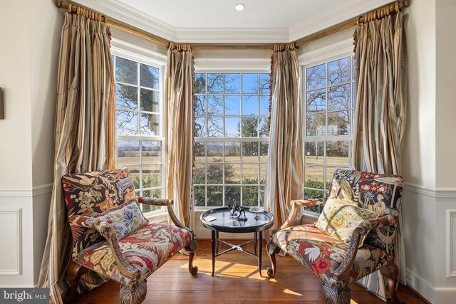  - sitting room featuring wood finished floors and ornamental molding