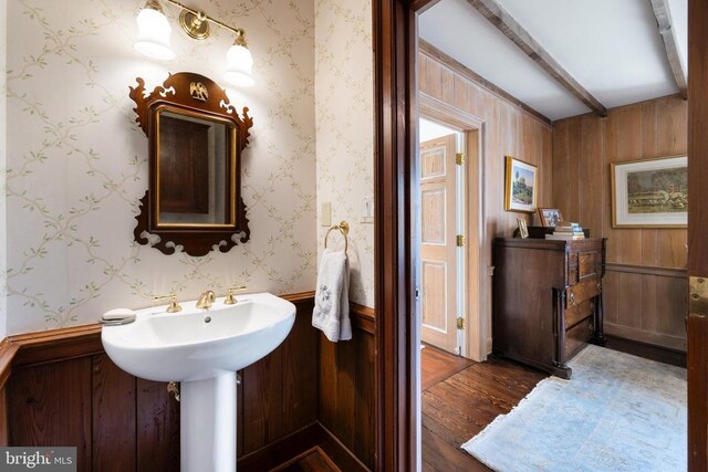  - bathroom with hardwood / wood-style floors, beam ceiling, and wood walls