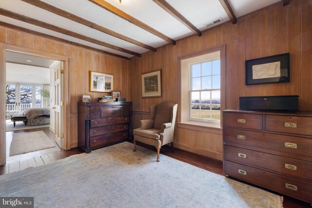  - living area featuring wood finished floors, beamed ceiling, and wood walls