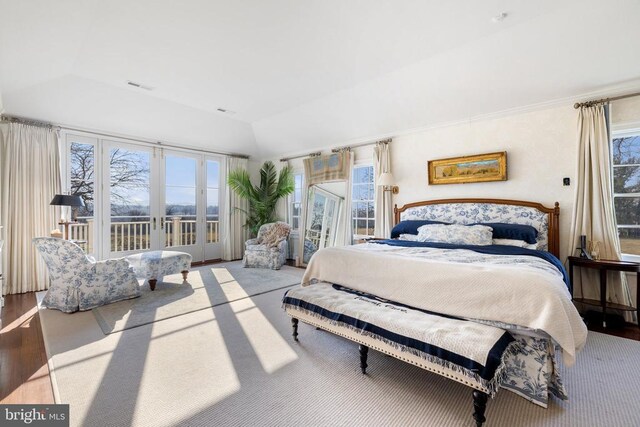  - bedroom featuring access to outside, lofted ceiling, and wood finished floors